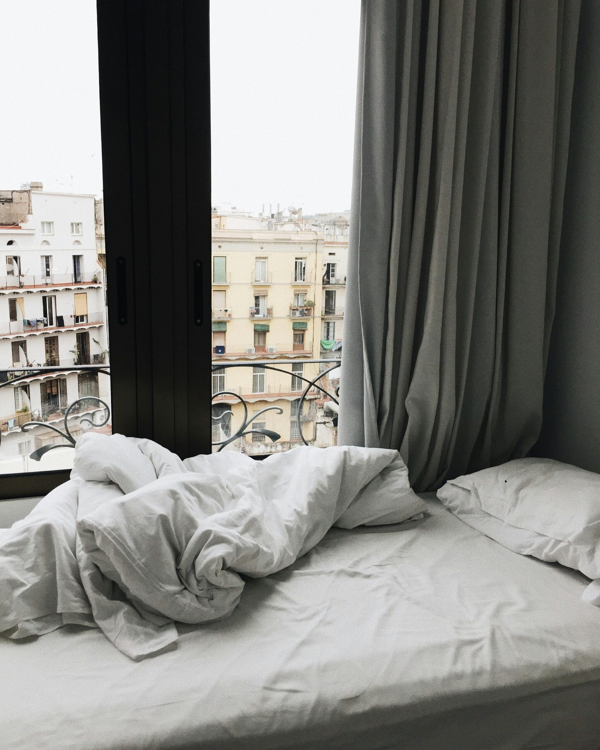 Modern bedroom interior showcasing a scenic view of Barcelona, Spain.